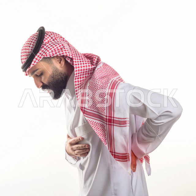 بورتريه لشاب سعودي خليجي مريض بايماءات الوجه و اليدين التي تدل على الألم و المعاناه ، آلام في الظهر، حالة مرضية ،  خلفية بيضاء