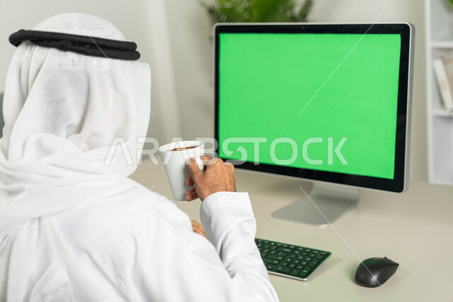 Marketing a website, chatting, conversations, and social networking, using a desktop computer with a green chroma background, a picture from the back of an Arab Gulf Emirati man wearing a kandora and a white ghutra, drinking coffee, making a video call, watching movies and series.