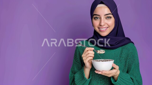 إتباع النظام الغذائي الصحي، وجبة افطار مغذية ومفيدة، بورتريه مقرب لشابة عربية خليجية سعودية محجبة تحمل بيدها طبق من الحبوب، النظر إلى الكاميرا بايماءات السرور والسعادة، خلفية بنفسجية