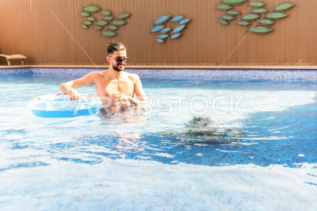 أب سعودي عربي يعلم ابنه مهارة السباحة , السباحة والغوص في أفضل المنتجعات السياحية , الاستجمام و الاسترخاء في عطلة الصيف . 