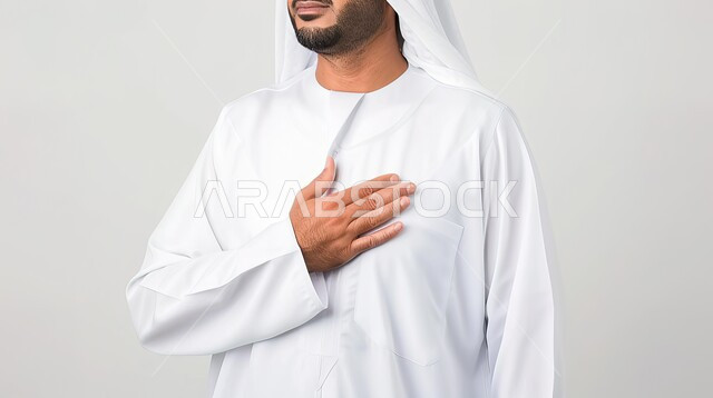 The concept of elegance, elegance and masculinity, attention to external appearance, a close-up portrait of an Arab Gulf Emirati man wearing traditional clothing, standing upright, gray background