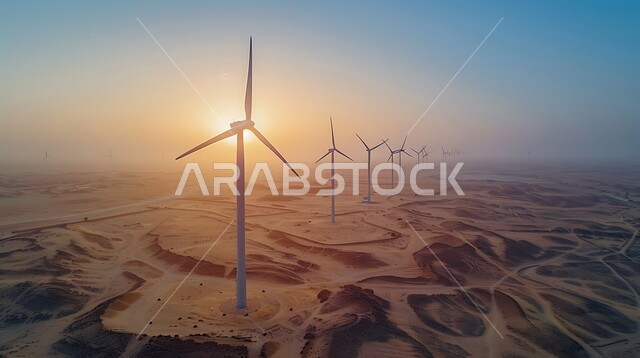 The concept of using environmentally friendly renewable energies, sustainable development with alternative energy in the Kingdom of Saudi Arabia, wind turbine fields and windmills amidst golden sand in desert areas.