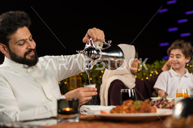 A happy Saudi Gulf family at the breakfast table in the month of Ramadan, drinking Arabic coffee after breakfast, a trip filled with varieties of delicious Saudi Arabian food, the month of Ramadan, Ramadan Kareem, Ramadan Lantern