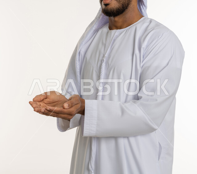 Condemning gestures indicating the command to stop doing something and forbidding it, a Saudi girl wearing the Gulf dress and feeling annoyed, rejected and abstained, silence to stop talking, a portrait of an Arab Emirati Gulf family raising its palm up, white background