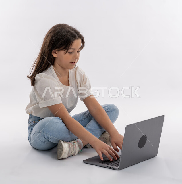 مفهوم الدراسة عن بعد, بورتريه لبنت عربية خليجية إماراتية ترتدي الزي الكاجوال وتجلس أمام الحاسوب المحمول، إجراء مكالمة فيديو، التواصل مع الأصدقاء، تصفح الإنترنت والمحادثات، التعليم الإلكتروني في الامارات، خلفية بيضاء