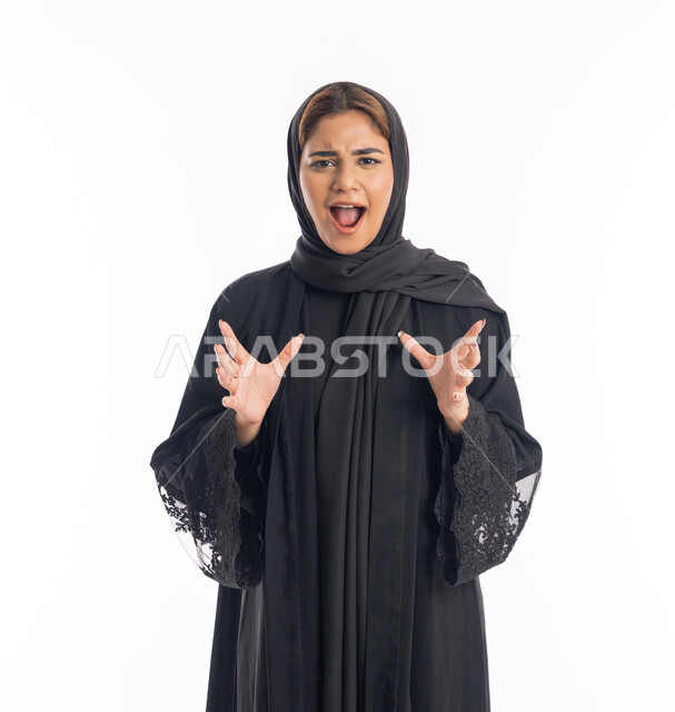 مفهوم الفرح بتحقيق شيء ما، شابة سعودية ، بورتريه مقرب لامرأة عربية خليجية اماراتية محجبة مبتسمة ترتدي العباءة السوداء ترفع يديها بإيماءات الحماس، خلفية بيضاء