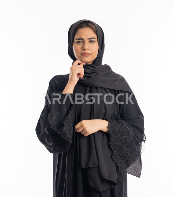 إيماءات الحيرة والقلق, محاولة إيجاد حل لشيء ما, التمعن والتركيز والتخطيط للمستقبل، بورتريه مقرب  لامرأه خليجيه سعوديه محجبة تضع يدها على ذقنها وتنظر بعيداً بتفكير وتأمل، النظر بشرود إلى مكان ما, سيدة عربية إماراتية ترتدي العباءة السوداء، خلفية بيضاء