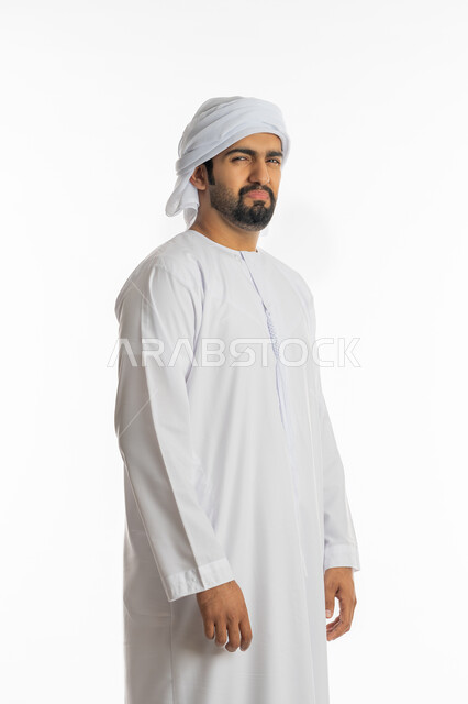 تعابير الانزعاج والغضب، الاهتمام بالمظهر الخارجي، الشعور بالحزن والضجر، بورتريه من الجانب لرجل عربي خليجي اماراتي يرتدي الكندورة الاماراتية والعمامة ينظر إلى الكاميرا بإيماءات التقزز والاسمزاز، خلفية بيضاء