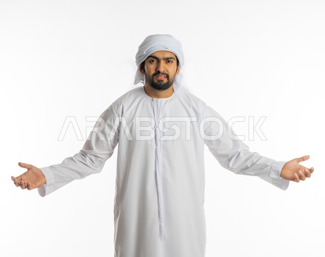 الإستفهام حول موضوع معين, بورتريه لرجل عربي خليجي اماراتي يرتدي الكندورة الإماراتية والعمامة البيضاء يرفع يديه نحو الأعلى بإيماءات عدم المعرفة, التساؤل والإستغراب والاستفسار عن أمر ما، الغموض وعدم الوضوح، خلفية بيضاء