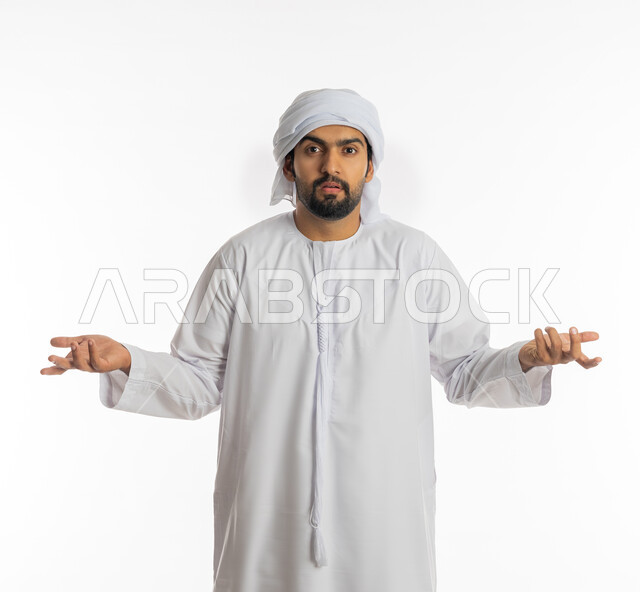 الغموض وعدم الوضوح، التساؤل والإستغراب والاستفسار عن أمر ما، الإستفهام حول موضوع معين, بورتريه لرجل عربي خليجي اماراتي يرتدي الكندورة الإماراتية والعمامة البيضاء يرفع يديه نحو الأعلى بإيماءات عدم المعرفة, خلفية بيضاء