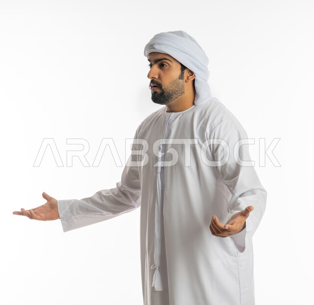 التساؤل والاستغراب والاستفسار من أمر ما، الإستفهام حول موضوع معين, بورتريه من الجانب لرجل عربي خليجي اماراتي يرتدي الكندورة الإماراتية والعمامة يرفع يديه نحو الأعلى بإيماءات عدم المعرفة، الغموض وعدم الوضوح، خلفية بيضاء