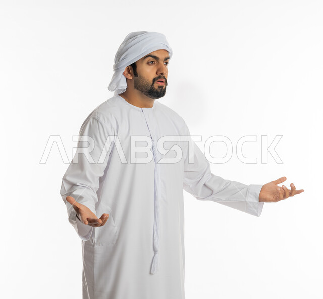 الغموض وعدم الوضوح، التساؤل والاستغراب والاستفسار من أمر ما، الإستفهام حول موضوع معين, بورتريه من الجانب لرجل عربي خليجي اماراتي يرتدي الكندورة الإماراتية والعمامة يرفع يديه نحو الأعلى بإيماءات عدم المعرفة، خلفية بيضاء
