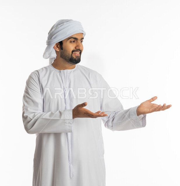 Gestures of carrying and lifting something, using the sense of touch to move holographic elements, portrait of an Emirati Gulf Arab man wearing an Emirati kandora and turban, pointing to his hand, pointing towards a specific goal, white background.