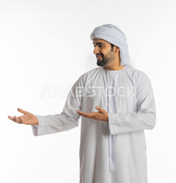 استخدام حاسة اللمس لتحريك العناصر الهولوجراميه، بورتريه لرجل عربي خليجي اماراتي يرتدي الكندورة الاماراتية والعمامة يشير الى يده، ايماءات حمل ورفع شيء ما، الإشارة نحو هدف معين، خلفية بيضاء
