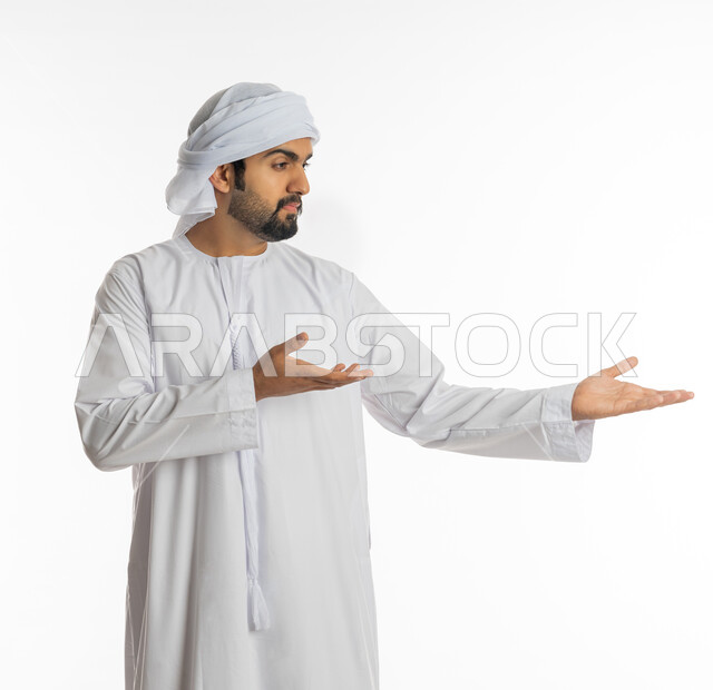 ايماءات حمل ورفع شيء ما، استخدام حاسة اللمس لتحريك العناصر الهولوجراميه، بورتريه لرجل عربي خليجي اماراتي يرتدي الكندورة الاماراتية والعمامة يشير الى يده، الإشارة نحو هدف معين، خلفية بيضاء