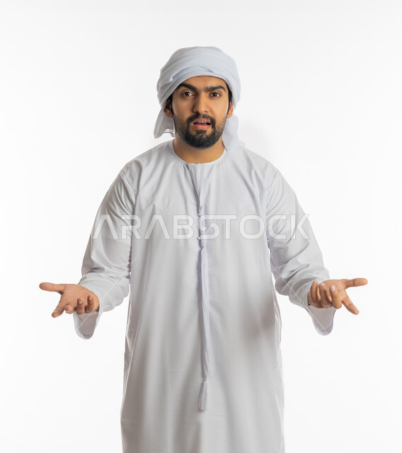 الغموض وعدم الوضوح، الإستفهام حول موضوع معين, بورتريه لرجل عربي خليجي اماراتي يرتدي الكندورة الإماراتية والعمامة يرفع يديه نحو الأعلى بإيماءات عدم المعرفة, التساؤل والإستغراب والاستفسار عن أمر ما، خلفية بيضاء