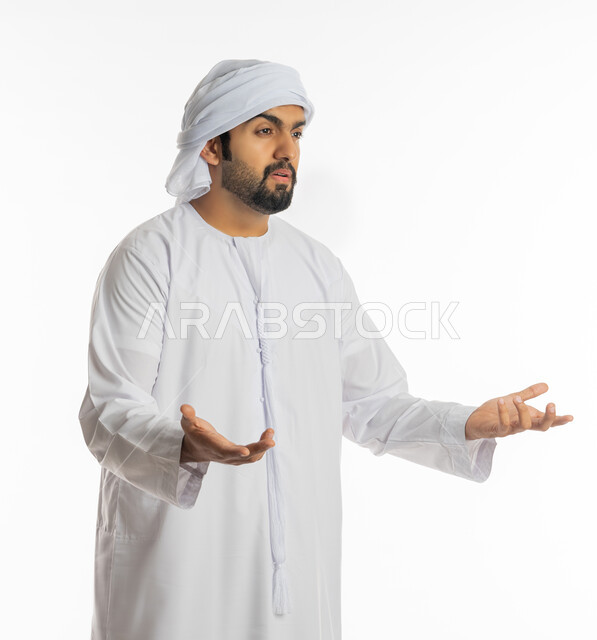 التساؤل والاستغراب والاستفسار من أمر ما، الإستفهام حول موضوع معين, بورتريه من الجانب لرجل عربي خليجي اماراتي يرتدي الكندورة الإماراتية والعمامة يرفع يديه نحو الأعلى بإيماءات عدم المعرفة، الغموض وعدم الوضوح، خلفية بيضاء