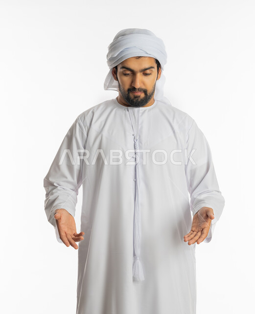 الاشارة إلى موقع ومكان معين, السؤال والاستفسار والاستفهام, بورتريه لرجل عربي خليجي إماراتي يرتدي الكندورة والعمامة ينظر إلى الأسفل, فتح اليدين لتحديد شيء ما, خلفية بيضاء