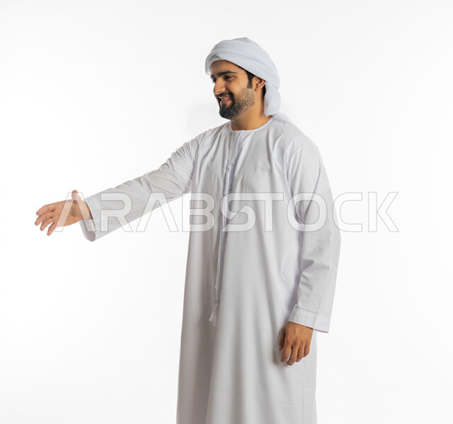 مفهوم الاستقبال والترحيب, التعارف و الصداقه وتكوين علاقات, إلقاء التحيه والسلام, بورتريه لرجل عربي خليجي إماراتي يرتدي الكندورة والعمامة يقوم بمد كفه للمصافحة، خلفية بيضاء
