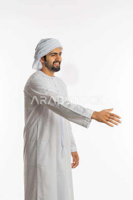 التعارف و الصداقه وتكوين علاقات, إلقاء التحيه والسلام, بورتريه لرجل عربي خليجي إماراتي يرتدي الكندورة والعمامة يقوم بمد كفه للمصافحة, مفهوم الاستقبال والترحيب، خلفية بيضاء
