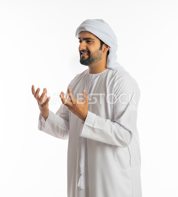 محاولة ضبط النفس وكتم الغضب, الحزن وطلب التوقف عن فعل الأخطاء, بورتريه لشاب عربي خليجي إماراتي يرتدي الكندورة والعمامة الاماراتية يرفع يديه بانزعاج, الوقوف بإيماءات العتاب والتوبيخ والرفض, خلفية بيضاء