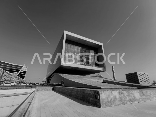 صورة مبنى من الطراز الحديث باللون الرمادي في دولة البحرين ، مغطى بزجاج عاكس لجمال السماء ، يتميز بشكل مربع يدل على الأناقة و الفخامة ، المنامة ، دولة البحرين