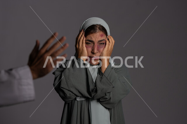 التعرض للأذى الجسدي من قبل الرجال, حقوق المرأة المسلمه ,آثار الكدمات البدنية, العلاقات الزوجية الفاشلة, 25 نوفمبر اليوم العالمي للقضاء على العنف ضد النساء ,بورتريه مقرب لشابة عربيه إماراتية خليجية محجبة تبتعد بتعابير الخوف و الذعر, سيدة سعودية حزينة, خلفية رمادية