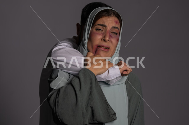 امراض نفسية ومشاكل زوجية, ايماءات الخوف و الالم, 25 نوفمبر اليوم العالمي للقضاء على العنف ضد النساء ,حقوق المرأة المسلمه ,آثار الكدمات البدنية, بورتريه مقرب لشابة عربيه إماراتية خليجية محجبة تتعرض للأذى الجسدي من قبل الرجال, سيدة سعودية حزينة, خلفية رمادية