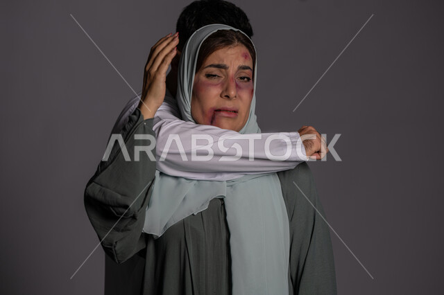 امراض نفسية ومشاكل زوجية, ايماءات الخوف و الالم, 25 نوفمبر اليوم العالمي للقضاء على العنف ضد النساء ,حقوق المرأة المسلمه ,آثار الكدمات البدنية, بورتريه مقرب لشابة عربيه إماراتية خليجية محجبة تتعرض للأذى الجسدي من قبل الرجال, سيدة سعودية حزينة, خلفية رمادية