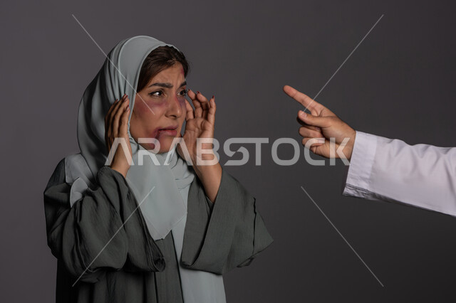 آثار الكدمات البدنية, التعرض للأذى الجسدي من قبل الرجال, العلاقات الزوجية الفاشلة, 25 نوفمبر اليوم العالمي للقضاء على العنف ضد النساء ,حقوق المرأة المسلمه ,بورتريه مقرب لشابة عربيه إماراتية خليجية محجبة تبتعد بتعابير الخوف و الذعر, سيدة سعودية حزينة, خلفية رمادية