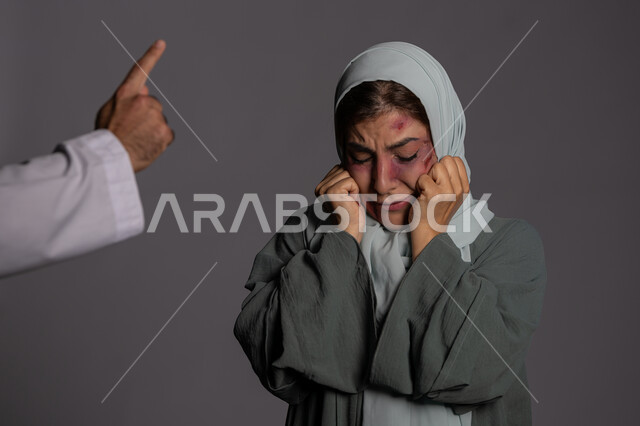 التعرض للأذى الجسدي من قبل الرجال, العلاقات الزوجية الفاشلة, 25 نوفمبر اليوم العالمي للقضاء على العنف ضد النساء ,حقوق المرأة المسلمه ,آثار الكدمات البدنية, بورتريه مقرب لشابة عربيه إماراتية خليجية محجبة تبتعد بتعابير الخوف و الذعر, سيدة سعودية حزينة, خلفية رمادية