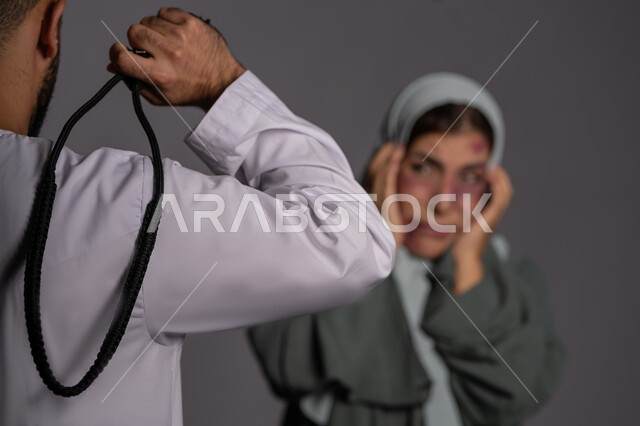 العلاقات الزوجية الفاشلة, التعرض للأذى الجسدي من قبل الرجال, سيدة سعودية حزينة, 25 نوفمبر اليوم العالمي للقضاء على العنف ضد النساء ,بورتريه مقرب لشابة عربيه إماراتية خليجية محجبة تضع يدها على وجهها بتعابير الخوف و البكاء, حقوق المرأة المسلمه، خلفية رمادية