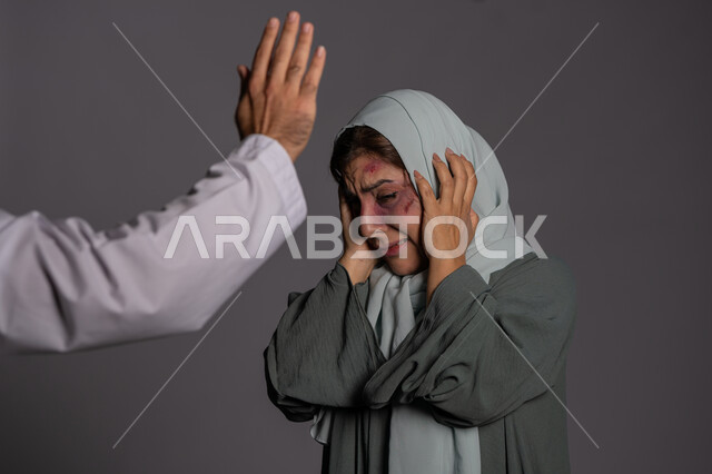 التعرض للأذى الجسدي من قبل الرجال, العلاقات الزوجية الفاشلة, سيدة سعودية حزينة, 25 نوفمبر اليوم العالمي للقضاء على العنف ضد النساء ,بورتريه مقرب لشابة عربيه إماراتية خليجية محجبة تضع يدها على وجهها بتعابير الخوف و البكاء, حقوق المرأة المسلمه، خلفية رمادية