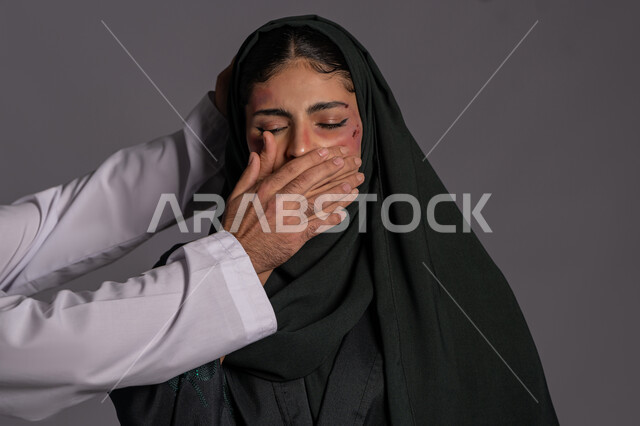إجبار الامرأة على السكوت من قبل الرجال, التعرض للأذى الجسدي، اليوم العالمي للقضاء على العنف ضد النساء 25 نوفمبر, العلاقات الزوجية الفاشلة, بورتريه مقرب لشابة عربيه إماراتية خليجية محجبة تغمض عينيها بإيماءات الخوف, سيدة سعودية حزينة, حقوق المرأة المسلمه، خلفية رمادية