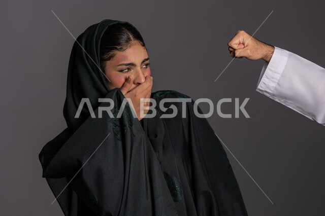 العلاقات الزوجية الفاشلة, سيدة سعودية حزينة, التعرض للأذى الجسدي من قبل الرجال, 25 نوفمبر اليوم العالمي للقضاء على العنف ضد النساء ,بورتريه مقرب لشابة عربيه إماراتية خليجية محجبة تضع يدها على فمها بتعابير الخوف و البكاء, حقوق المرأة المسلمه، خلفية رمادية