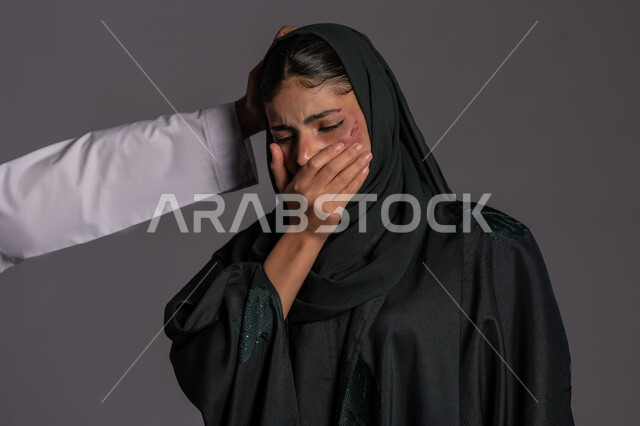 التعرض للأذى الجسدي من قبل الرجال, العلاقات الزوجية الفاشلة, 25 نوفمبر اليوم العالمي للقضاء على العنف ضد النساء ,بورتريه مقرب لشابة عربيه إماراتية خليجية محجبة تضع يدها على فمها بتعابير البكاء, سيدة سعودية حزينة, حقوق المرأة المسلمه، خلفية رمادية