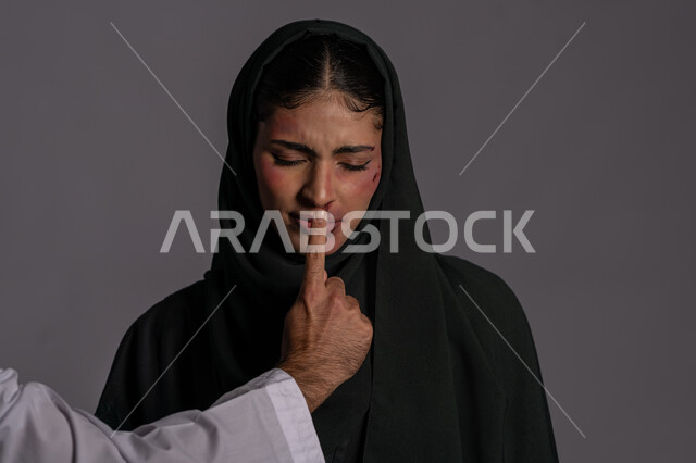 إخفاء آثار الكدمات الجسدية ,اليوم العالمي للقضاء على العنف ضد النساء 25 نوفمبر ,إجبار الامرأة على السكوت من قبل الرجال ,العلاقات الزوجية الفاشلة, بورتريه مقرب لشابة عربيه إماراتية خليجية محجبة تغمض عينيها بتعابير الانهيار, سيدة سعودية حزينة, حقوق المرأة المسلمه، خلفية رمادية