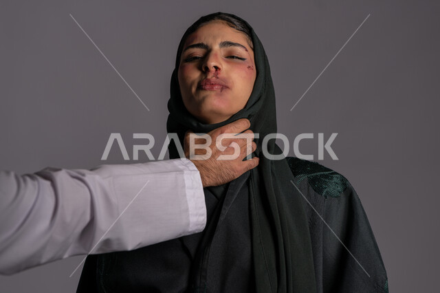 التعرض للأذى الجسدي من قبل الرجال, امراض نفسية ومشاكل زوجية, 25 نوفمبر اليوم العالمي للقضاء على العنف ضد النساء ,حقوق المرأة المسلمه ,آثار الكدمات البدنية, بورتريه مقرب لشابة عربيه إماراتية خليجية محجبة تغمض عيناها بايماءات الاختناق ,سيدة سعودية حزينة, خلفية رمادية