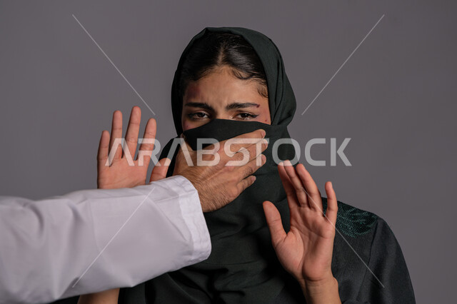 إجبار الامرأة على السكوت من قبل الرجال ,العلاقات الزوجية الفاشلة, 25 نوفمبر اليوم العالمي للقضاء على العنف ضد النساء ,آثار الكدمات الجسدية, بورتريه مقرب لشابة عربيه إماراتية خليجية محجبة تنظر الى الكاميرا بتعابير الخوف, سيدة سعودية حزينة, حقوق المرأة المسلمه، خلفية رمادية