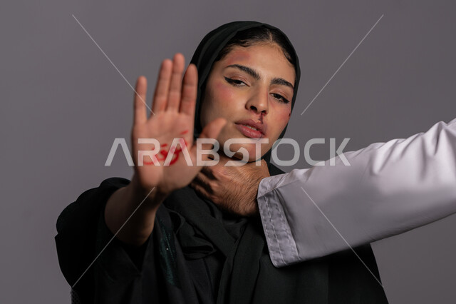 التعرض للأذى الجسدي من قبل الرجال, حقوق المرأة المسلمه ,امراض نفسية ومشاكل زوجية, آثار الكدمات البدنية, بورتريه مقرب لشابة عربيه إماراتية خليجية محجبة ترفع كفها للاعلى بعبارة توقف, 25 نوفمبر اليوم العالمي للقضاء على العنف ضد النساء ,سيدة سعودية حزينة, خلفية رمادية