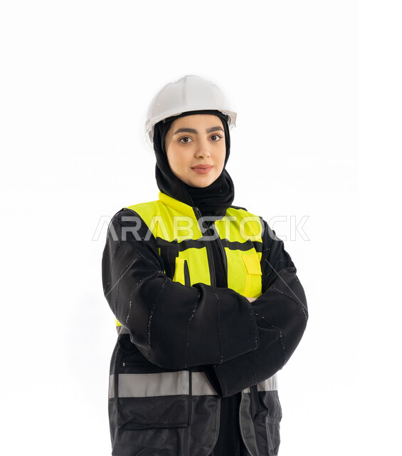 Project monitoring and supervision, architectural concept, close-up portrait of an Arab Gulf Emirati female engineer wearing an abaya, jacket and protective helmet standing with folded hands, veiled Saudi girl looking at the camera with gestures of firmness and seriousness, engineering professions and jobs, white background