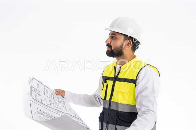 النظر الى شيء ما بإيماءات البهجة والسرور، الإشراف على العمل ومتابعته، تدقيق مخططات المشروع، مهن ووظائف هندسية في الإمارات العربية المتحدة، بورتريه مقرب لمهندس عربي خليجي اماراتي يرتدي الكندورة وسترة وخوذة الحماية الخاصة بالعمل يمسك بيده مخطط هندسي، خلفية بيضاء