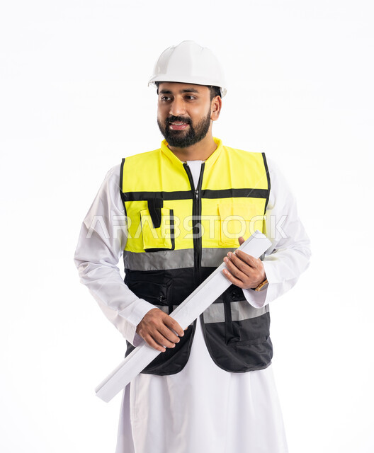 النظر إلى شيء ما بإيماءات البهجة والسرور، مهن ووظائف هندسية في الإمارات العربية المتحدة، بورتريه لمهندس عربي خليجي اماراتي يرتدي الكندورة الاماراتية وسترة وخوذة الحماية الخاصة بالعمل يمسك بيده مخطط هندسي، التدقيق والإشراف على مخططات المشروع، خلفية بيضاء