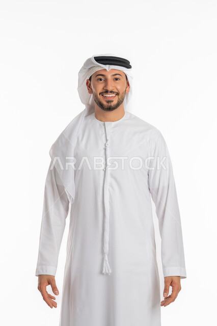 The concept of masculinity and self-confidence, taking personal photos for official documents, a portrait of a smiling Emirati Gulf Arab man wearing a kandura and ghutra looking at the camera with an expression of pleasure and happiness, standing ready and straight, elegance and interest in external appearance, white background