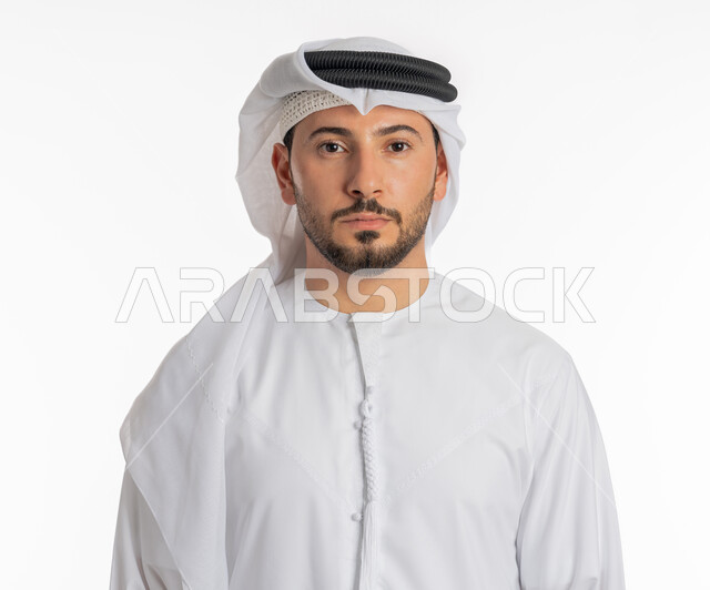 Elegance and interest in appearance, taking personal photos for official documents, the concept of masculinity and self-confidence, close-up portrait of an Arab Gulf Emirati man wearing a kandura and a ghutra looking at the camera with an expression of firmness and seriousness, standing ready and straight, white background