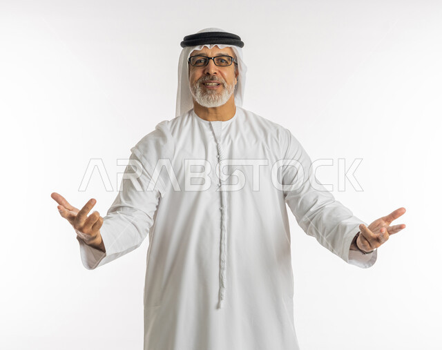 الفوز والنصر والحب, علامات وإشارات مشعة بالأمل والتفاؤل, الوقوف باستقامة والنظر إلى الكاميرا, بورتريه لرجل كبير السن عربي خليجي إماراتي يرتدي الكندورة و الغترة يرفع يده باشارة الاصابع الثلاث, المثابرة والتميز والتحديات لتحقيق النجاح, خلفية بيضاء