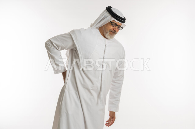 طلب المساعده للذهاب الى الطبيب, التعب والإرهاق و الحاجه للعلاج, أمراض المفاصل و العضلات ,الاحساس بألم في العمود الفقري , بورتريه لرجل مسن عربي خليجي اماراتي يرتدي الكندورة و الغترة و النظارات الطبية يشعر بأوجاع في أسفل الظهر, خلفية بيضاء