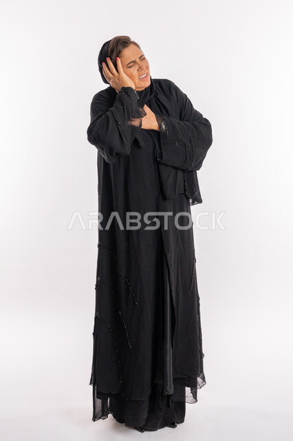 الاحساس بالدوخة وعدم التوازن, طلب المساعده للذهاب الى المستشفى، بورتريه لسيدة عربية سعودية محجبة ترتدي العباءة السوداء تضع يدها على رأسها بتعابير التعب والإرهاق و الحاجه للعلاج, امرأة خليجية اماراتية تشعر بالمرض و الصداع, الجسم بالطول الكامل, خلفية بيضاء
