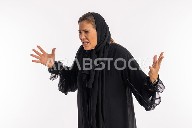 الحياه الفاشله و الامراض النفسيه ,ايماءات البكاء و الغضب و الاثارة, بورتريه لامرأة عربيه خليجية اماراتية محجبة ترتدي العباءة السوداء ترفع يديها للأعلى بتعابير الحزن الشديد, سيدة سعودية تشعر بالانزعاج و الرغبة بالانتقام, خلفية بيضاء