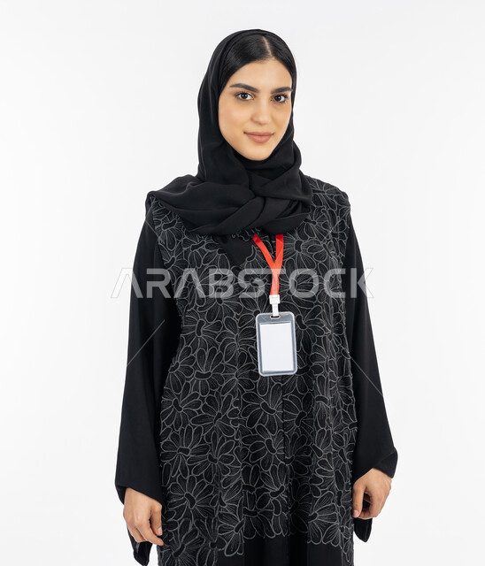 Wearing a personal badge, self-expression, gestures of self-confidence, portrait of an Emirati Gulf Arab woman wearing an abaya looking at the camera, a Saudi woman wearing a blank card with a red ribbon, the concept of elegance and concern for external appearance, white background